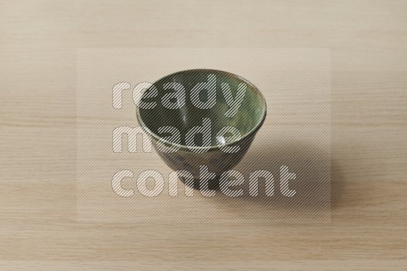 A decorative pottery bowl on light wooden background