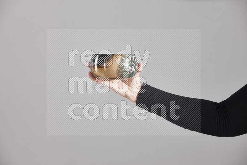 A woman in black abaya holding different pottery essentials in different positions