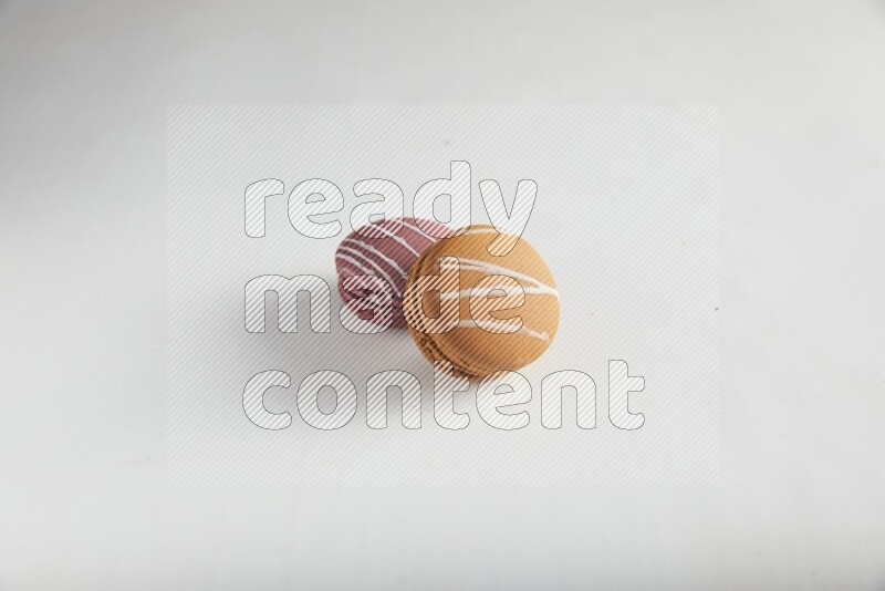 45º Shot of of two assorted Brown Irish Cream, and Red Poppy Flower macarons on white background