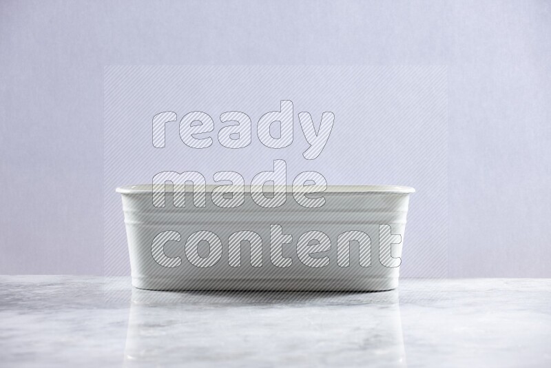 An empty white plant pot on grey marble background