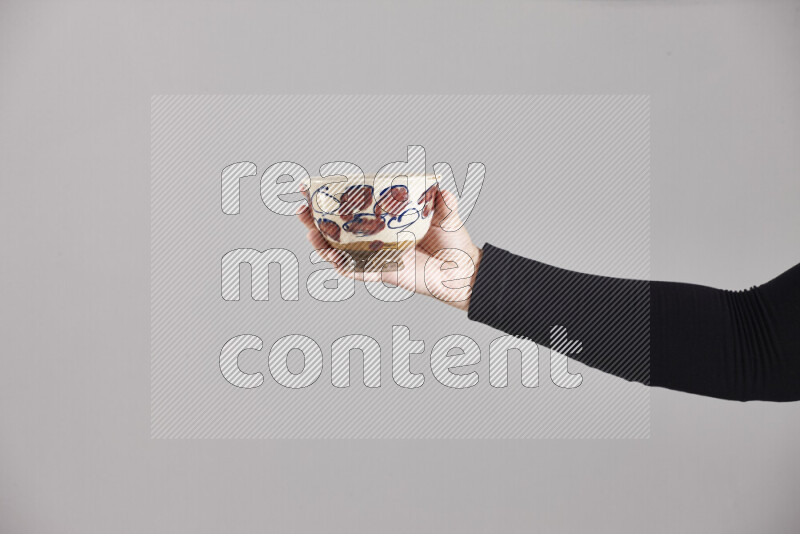 A woman in black abaya holding different pottery essentials in different positions