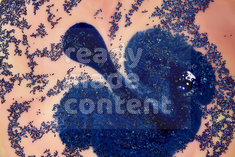 A close-up of sparkling blue glitter scattered on swirling blue and orange background