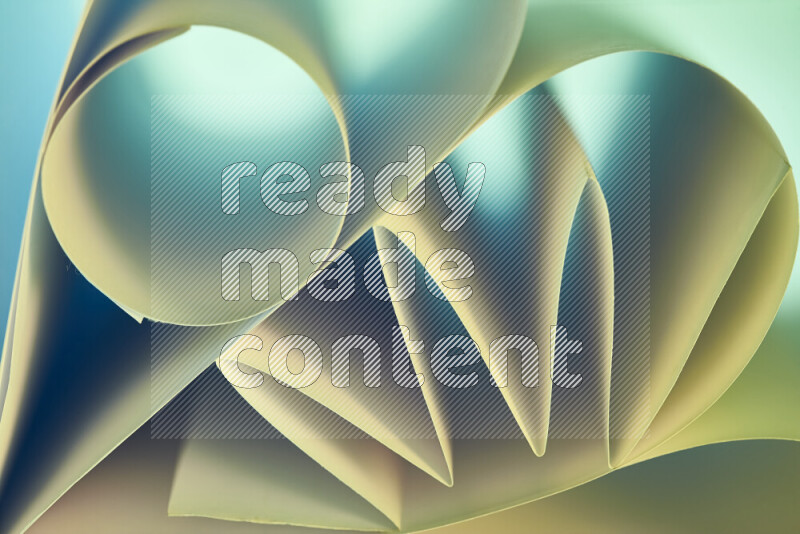 An artistic display of paper folds creating a harmonious blend of geometric shapes, highlighted by soft lighting in green and warm tones