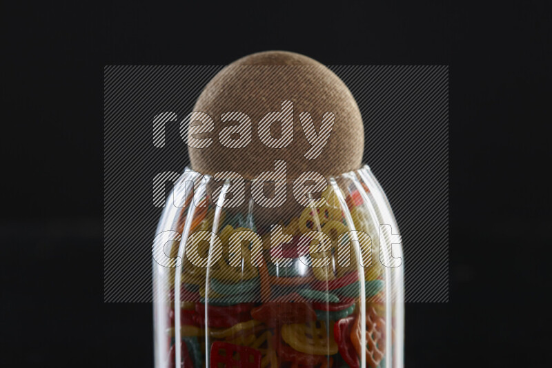 Snacks in a glass jar on black background