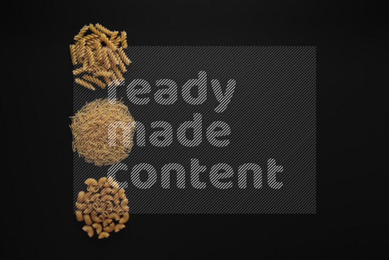 Different pasta types in 3 bunches on black background