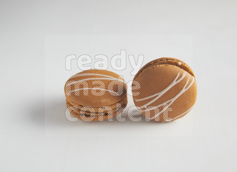 45º Shot of two Brown Irish Cream macarons on white background