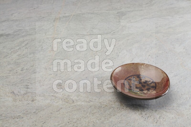 A decorative pottery plate on grey marble background
