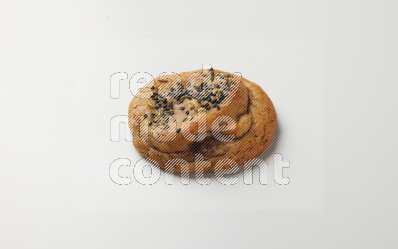 Hasawi cookie field with date and decorated by black seed and Anise grain on a white background