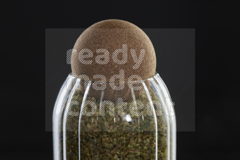 Freekeh in a glass jar on black background