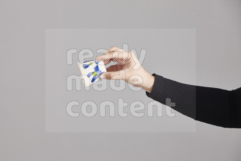 A woman in black abaya holding different pottery essentials in different positions