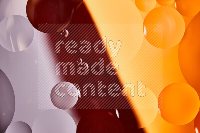 Close-ups of abstract oil bubbles on water surface in shades of white and orange