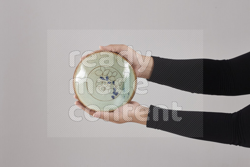 امرأة ترتدي عباءة سوداء تحمل أدوات فخارية مختلفة في أوضاع متعددة