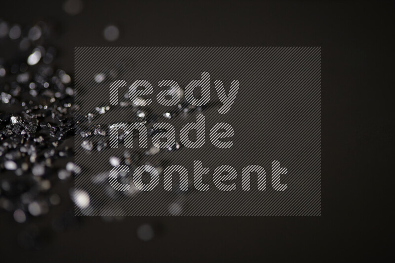 قطع زجاجية سوداء لامعة متناثرة على خلفية سوداء