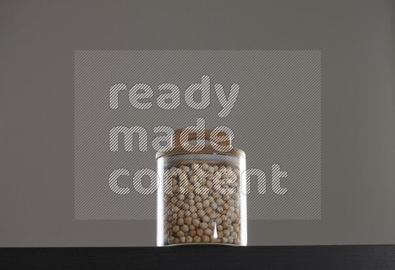 Chickpeas in a glass jar on black background