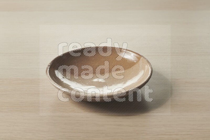 A multicolored pottery plate on light wooden background