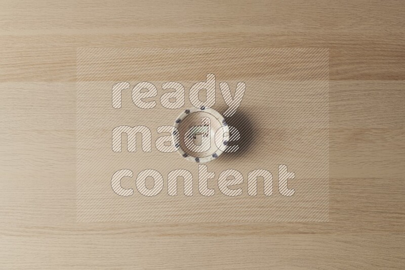 A decorative pottery bowl on light wooden background