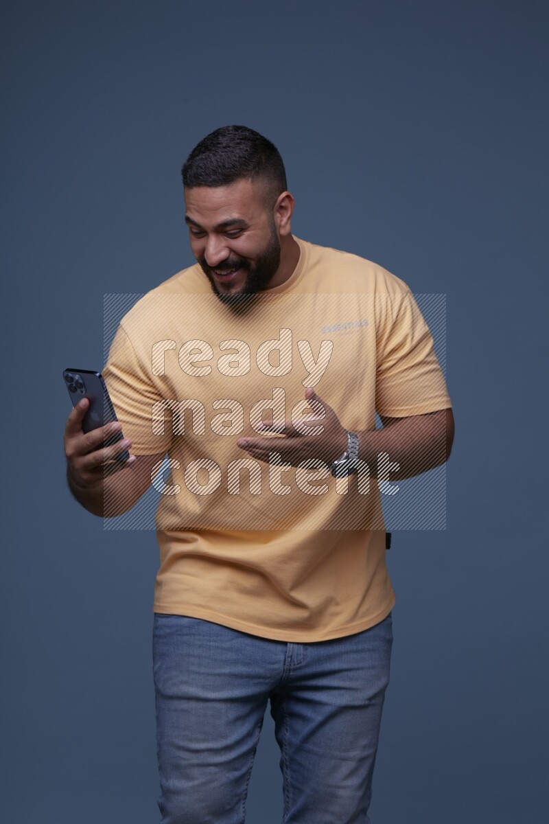 A man having a Video Calling on Blue Background wearing Orange T-shirt
