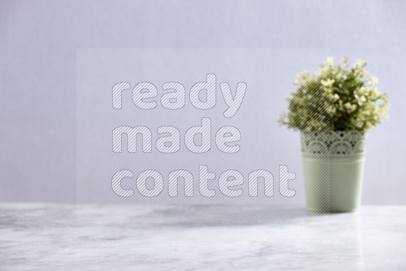 Artificial plant in green decorative pot on grey marble background