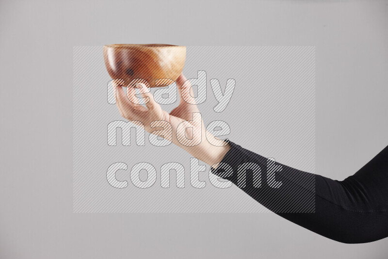 A woman in black abaya holding different wooden essentials in different positions