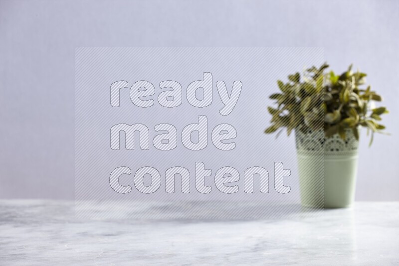 Artificial plant in green decorative pot on grey marble background