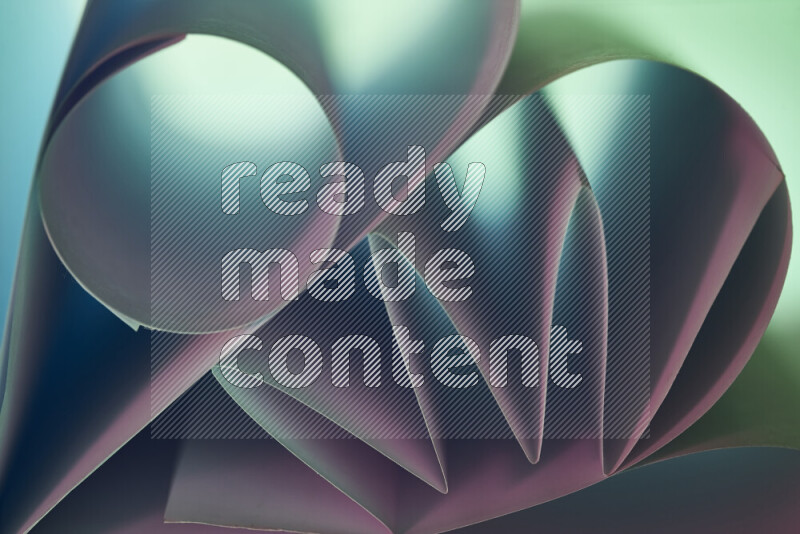 عرض فني لطيات الورق تخلق مزيج من الأشكال الهندسية، مضاءة بإضاءة ناعمة بدرجات اللون الأخضر والوردي