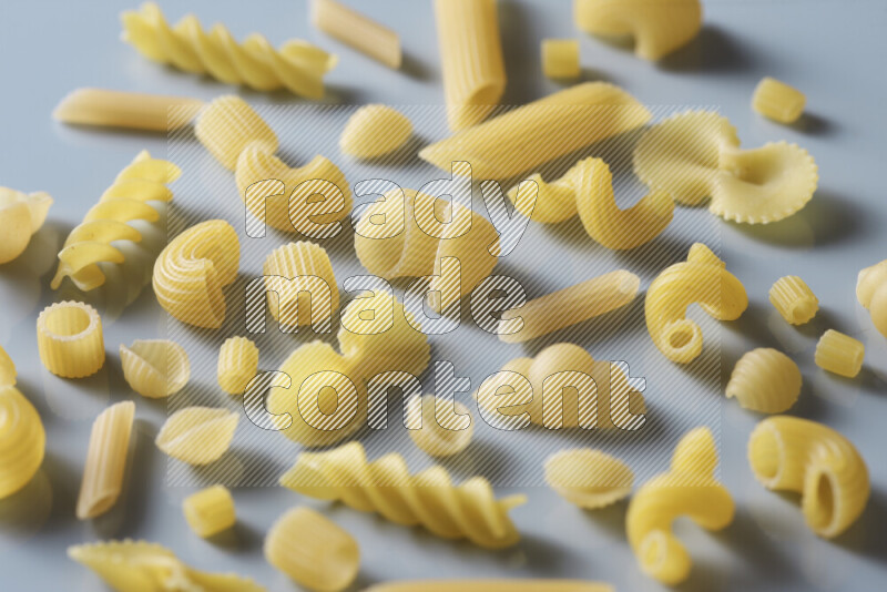 Different pasta types on light blue background