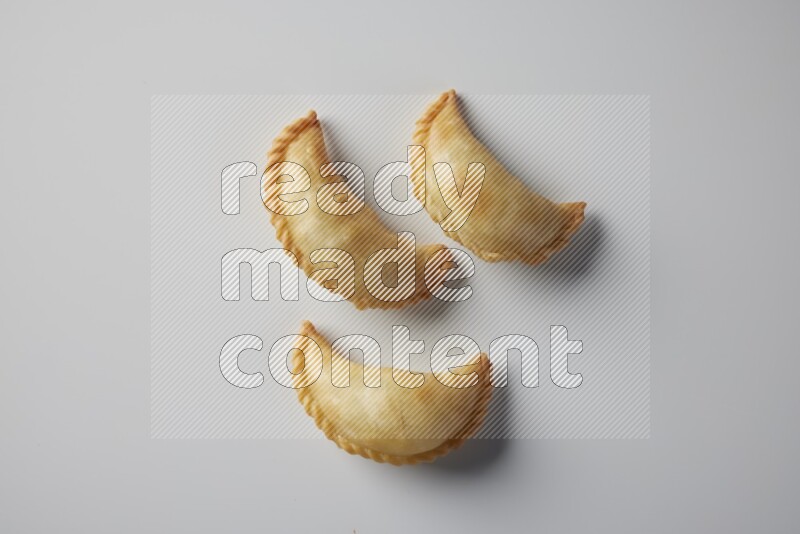 Three fried sambosa from a top angle on a white background