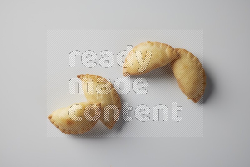 Four fried sambosa from a top angle on a white background