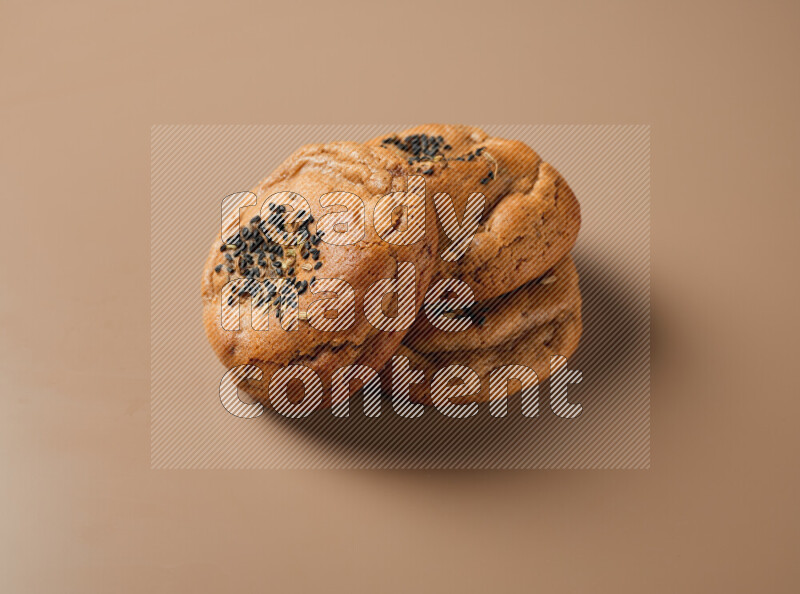 Hasawi cookies field with date and decorated by black seed and Anise grain on a brown background