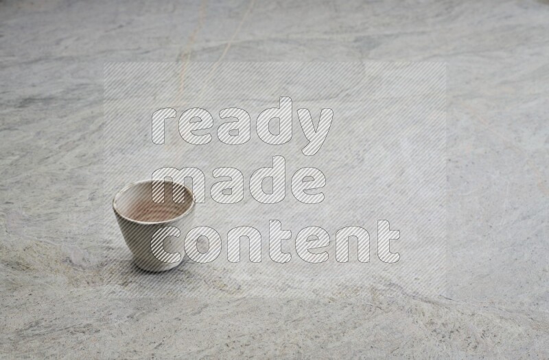 A multicolored pottery Cup on grey marble background