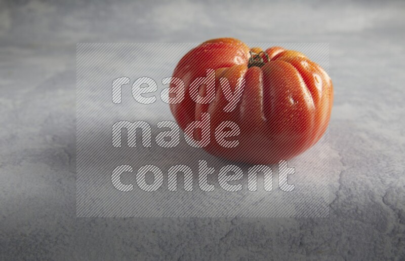 45 degree single heirloom tomato on a light blue textured background