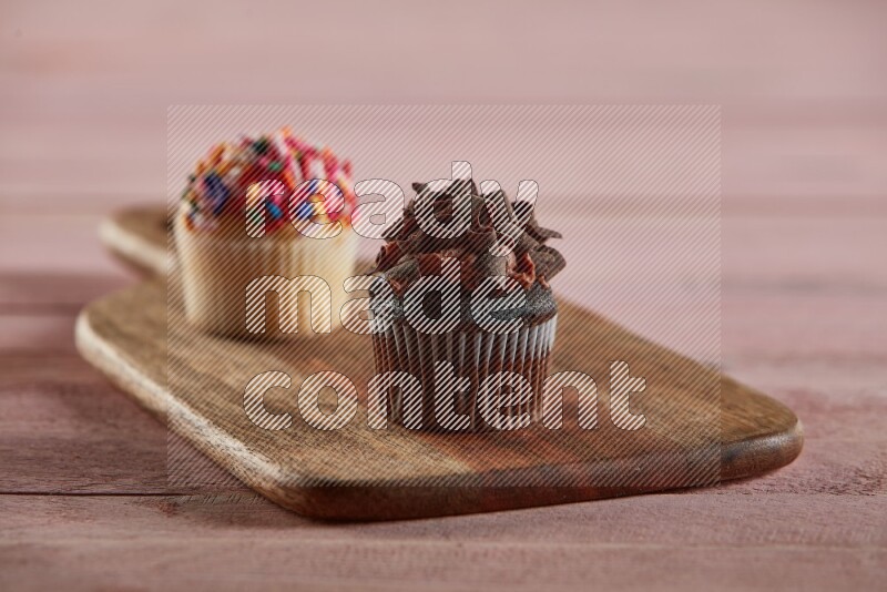 Chocolate mini cupcake topped with chocolate curls on a wooden board