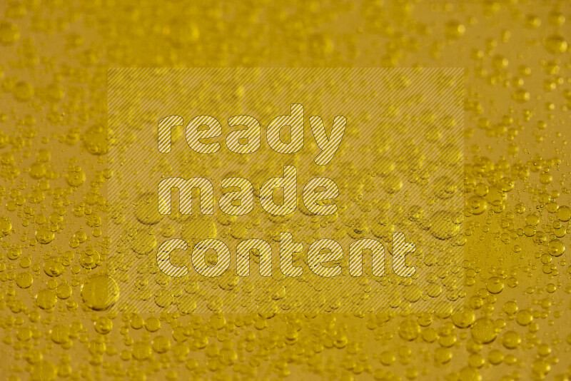 Close-ups of abstract water drops on oil Surface on yellow background