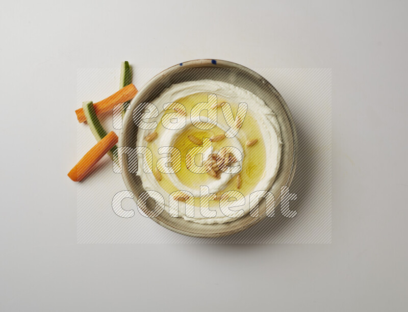 Lebnah garnished with pine nuts in a grey pottery plate on a white background