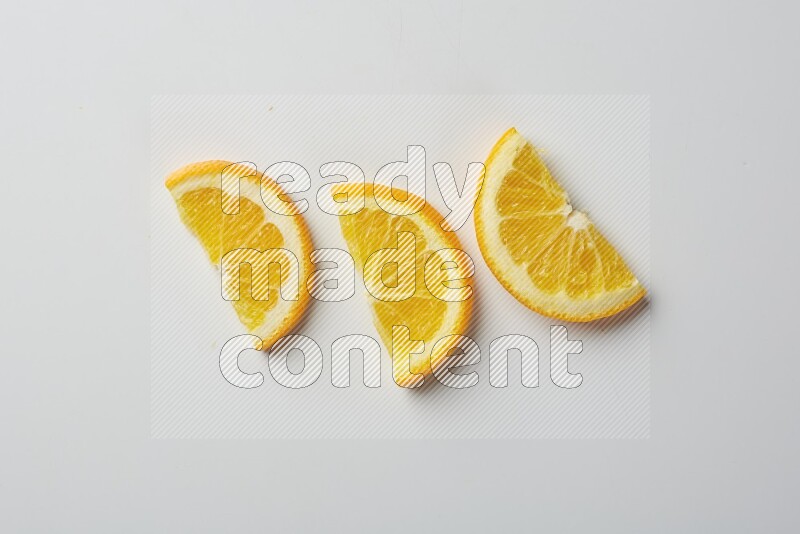 Three halves of an orange slices on white background