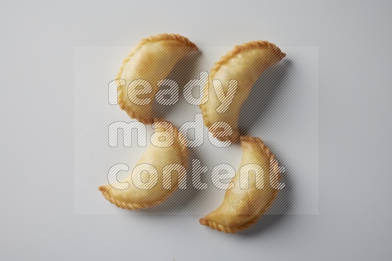 Four fried sambosa from a top angle on a white background
