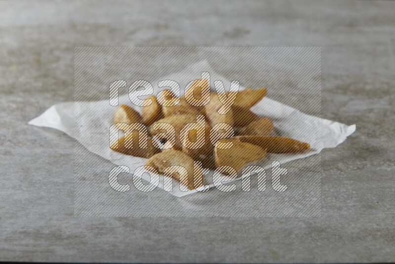 wedges potato on parchment paper on grey textured counter top