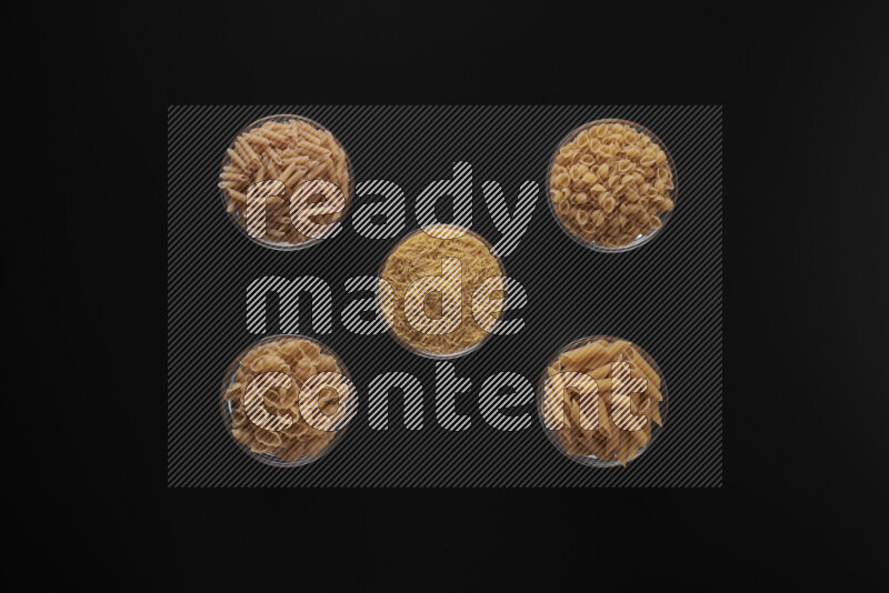 أنواع مختلفة من المعكرونة في أوعية زجاجية علي خلفية سوداء