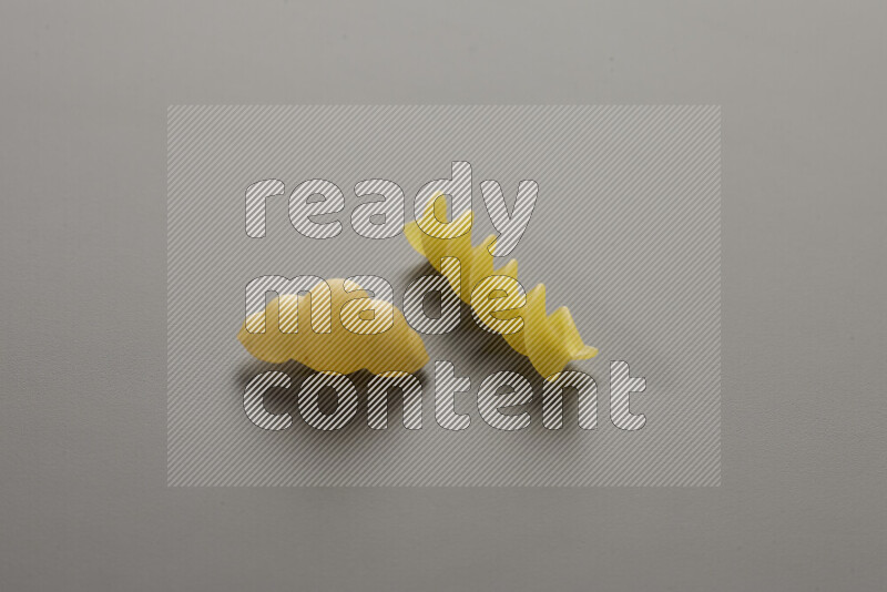 Snails pasta with other types of pasta on grey background