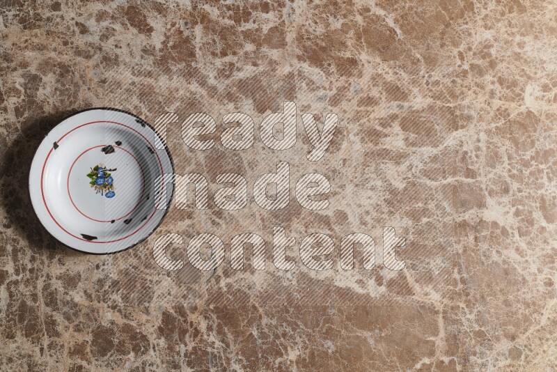 A vintage metal plate on beige marble background