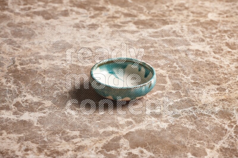 A multicolored pottery plate on beige marble background