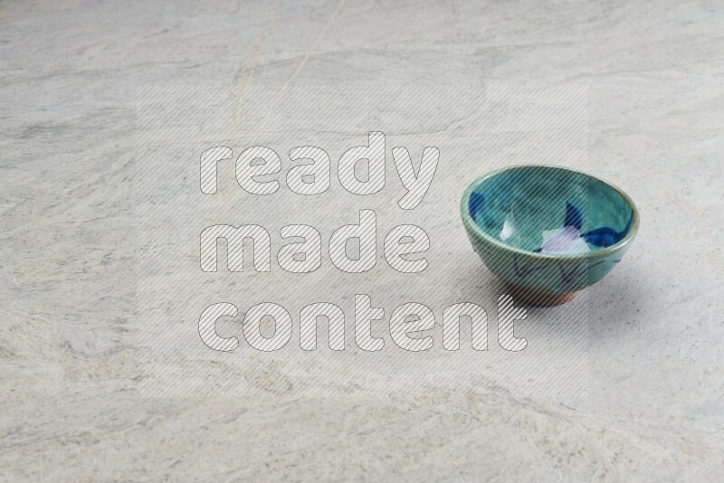 A multicolored pottery bowl on grey marble background