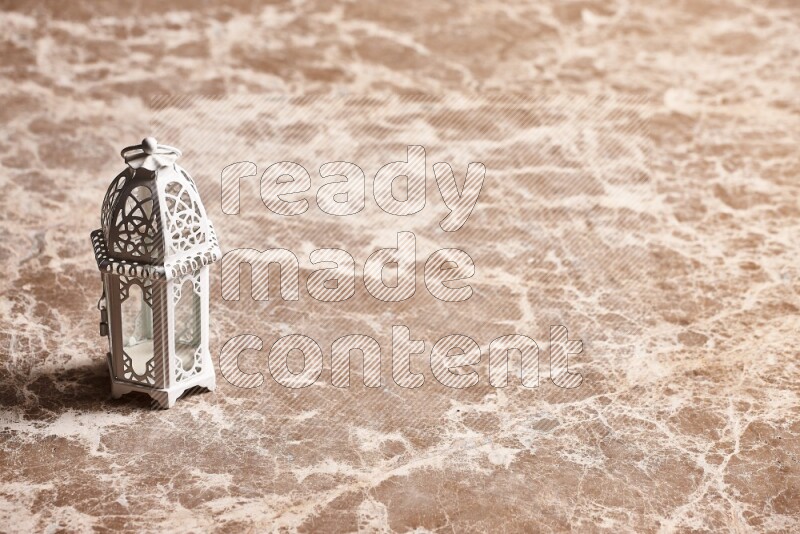 فانوس للشموع على خلفية رخام بيج