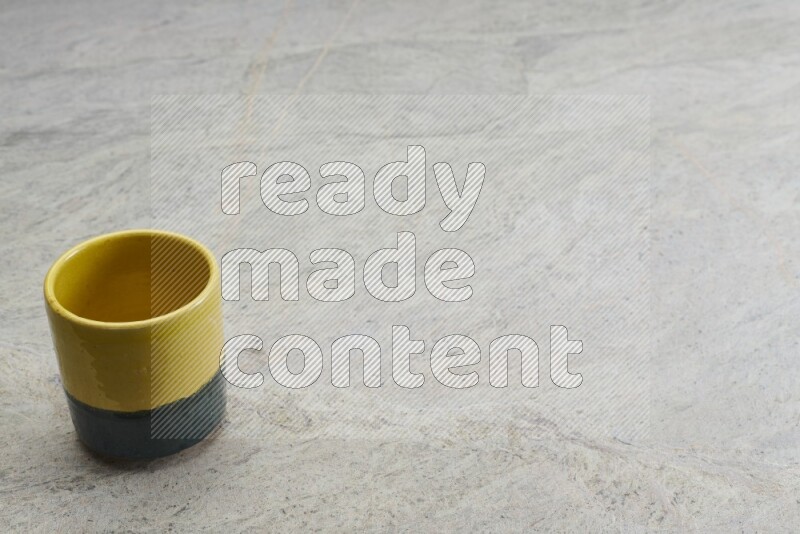 A multicolored pottery Cup on grey marble background