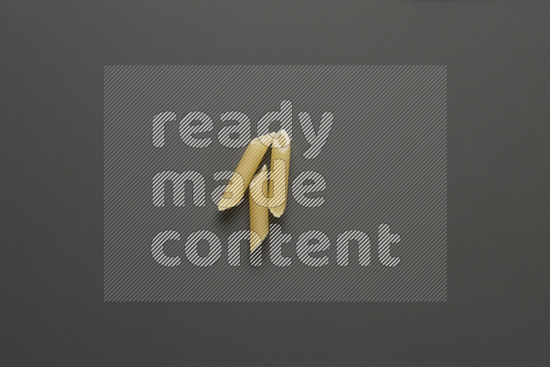Mini penne pasta on grey background