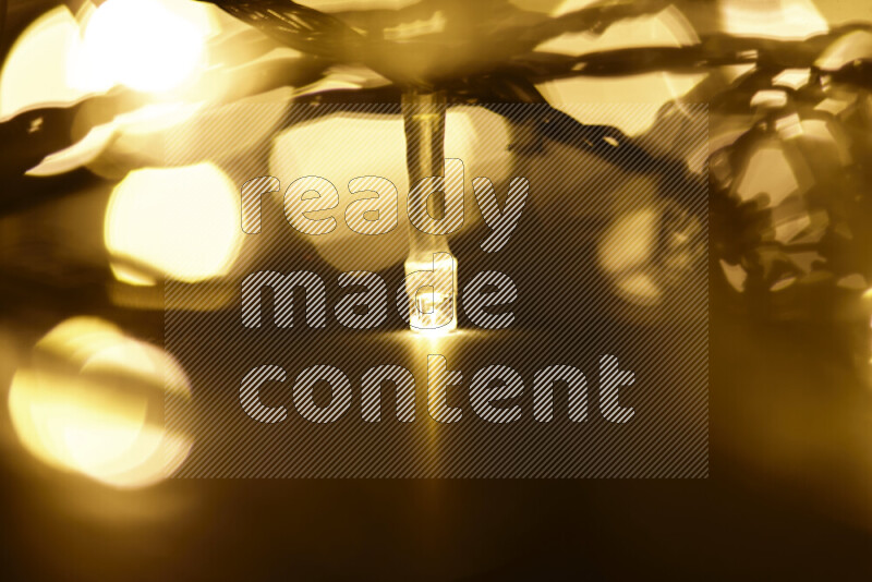 Light bulbs glowing against backdrop of golden bokeh