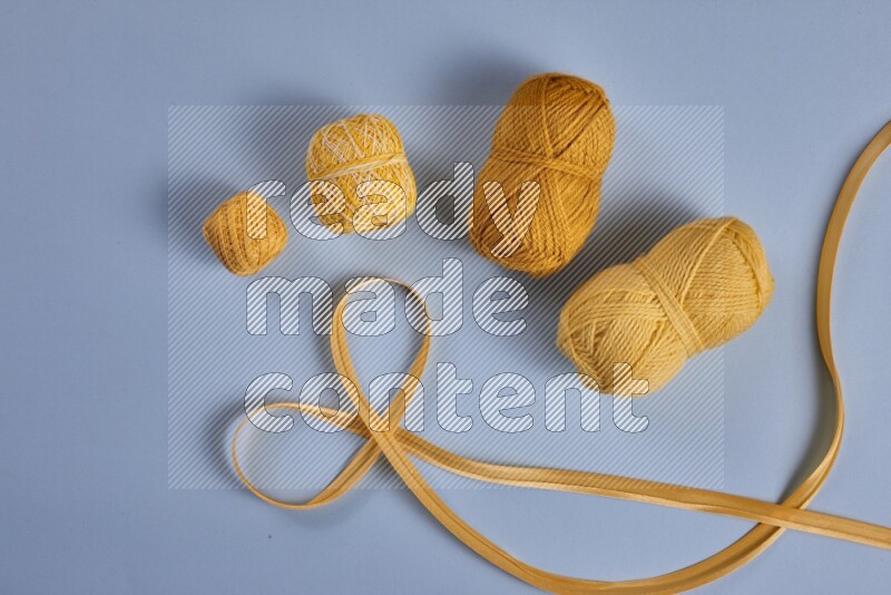 A yellow collection of sewing and tailoring tools arranged on a blue background