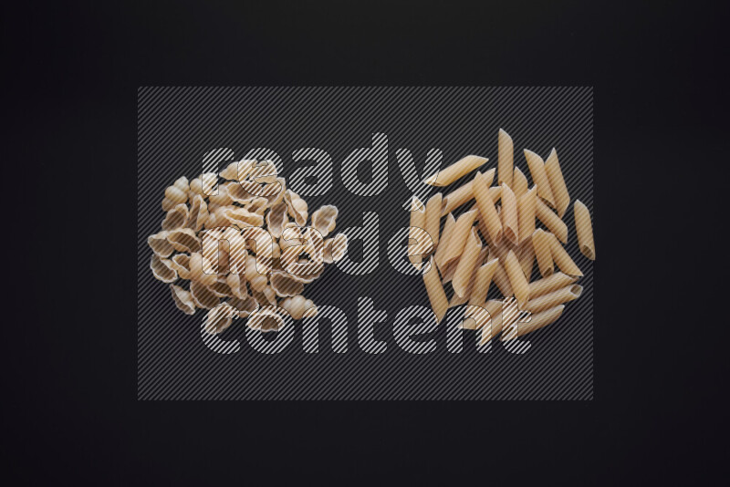 Different pasta types in bunches on black background