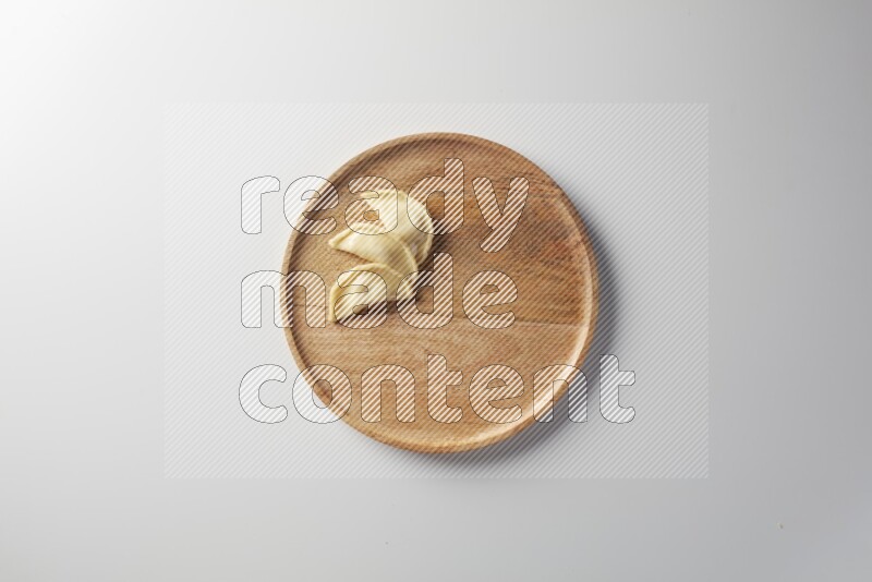 Three Sambosas on a wooden round plate on a white background
