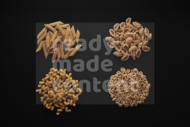 Different pasta types in bunches on black background